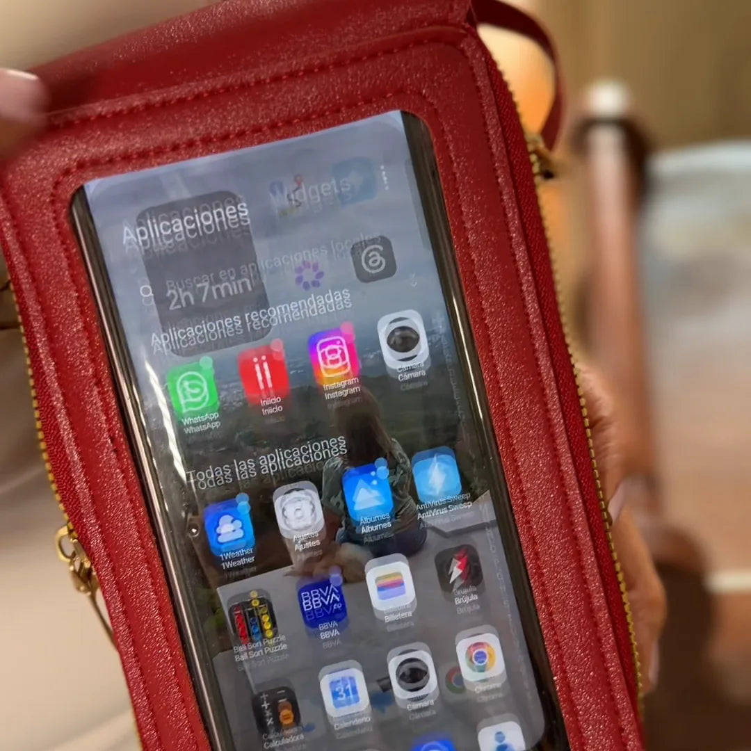 Mujer usando el celular a través de la ventana táctil del bolso portacelular rojo